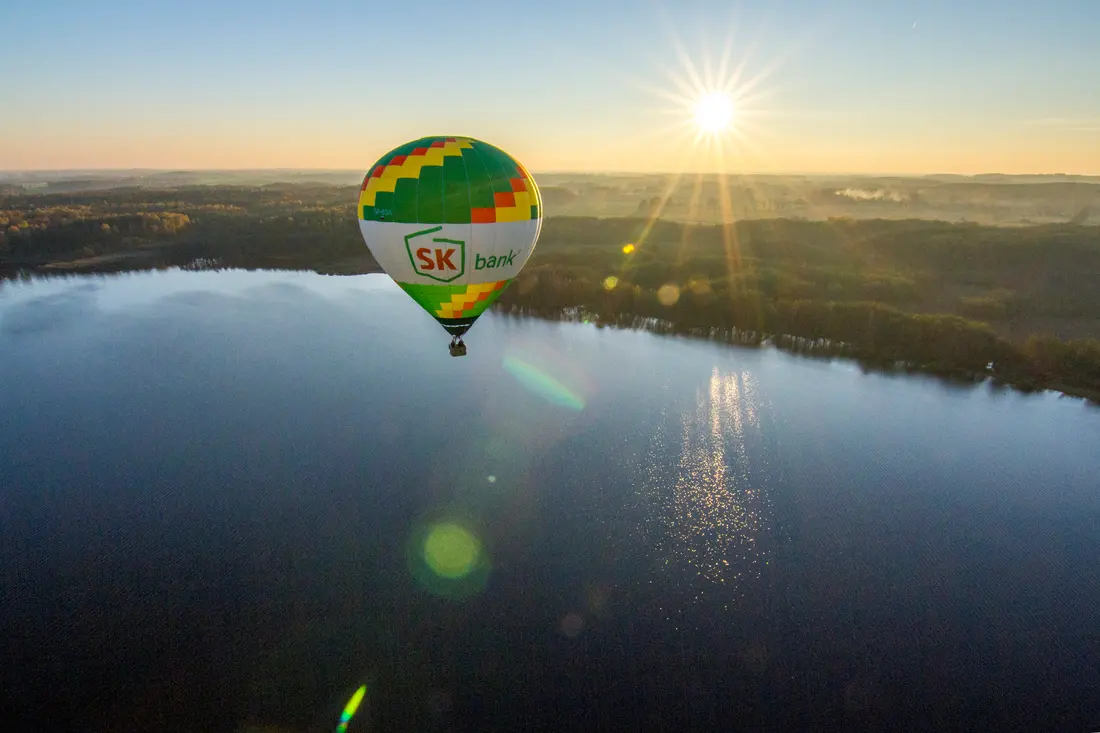 A hot-air balloon over a lake at dawn